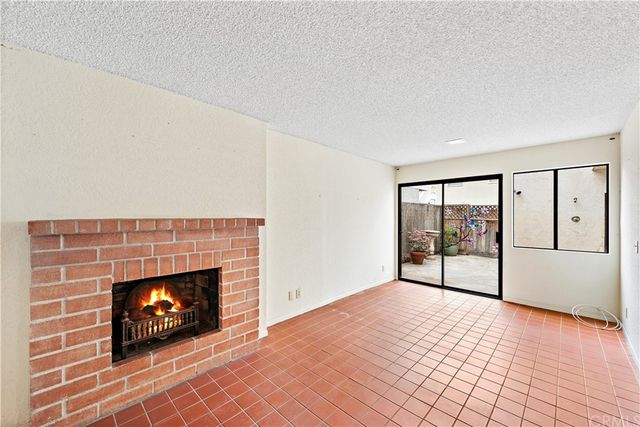 a view of an empty room with a fireplace and window