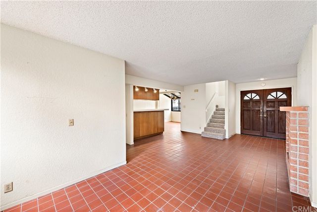 a view of an empty room with stairs and a window
