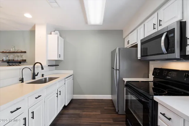 a kitchen with stainless steel appliances granite countertop a sink stove and microwave