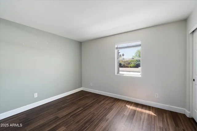 a view of a room that has wooden floor and window