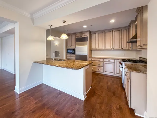 a kitchen with kitchen island a sink a stove and cabinets
