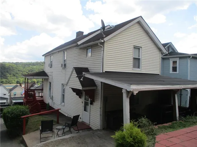 a view of house with backyard outdoor seating and hardwood