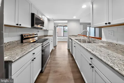 a large kitchen with stainless steel appliances granite countertop a lot of counter space