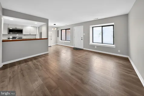 a view of a kitchen with wooden floor and windows