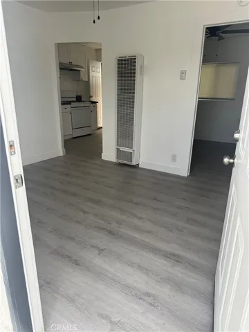 a view of a hallway with wooden floor and a cabinet