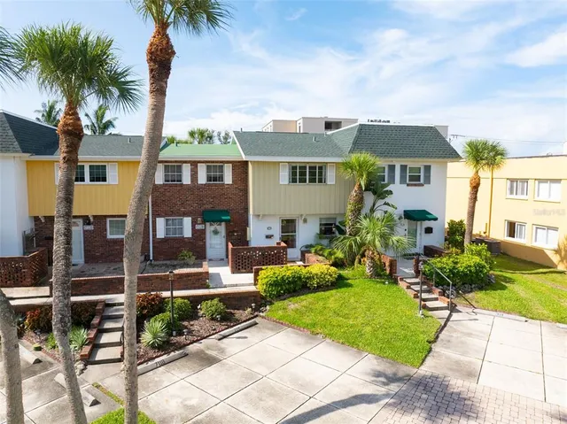a front view of a house with garden and plants