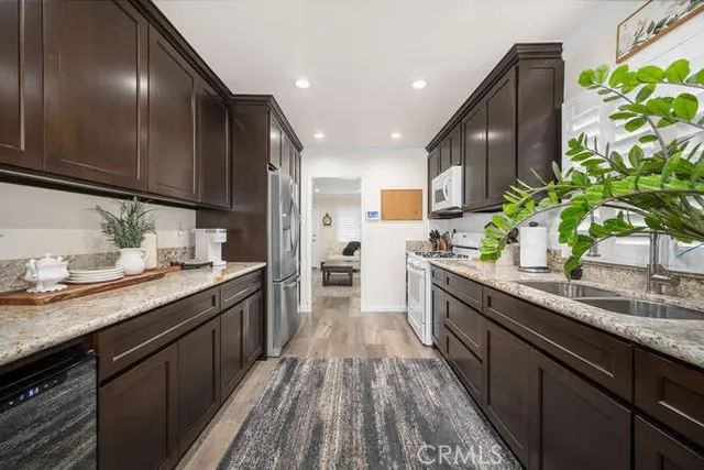 a kitchen with granite countertop stainless steel appliances stove a sink and cabinets
