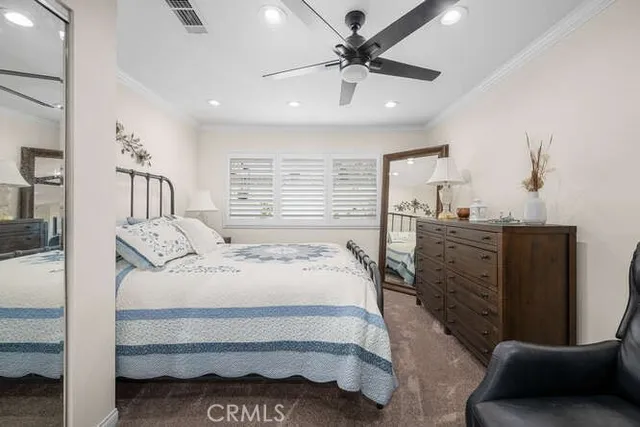 a spacious bedroom with a bed a couch and a chandelier