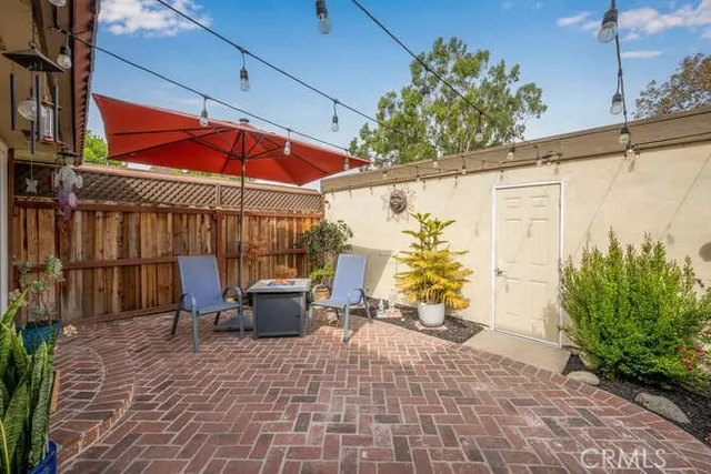 a view of a patio with a table and chairs under an umbrella
