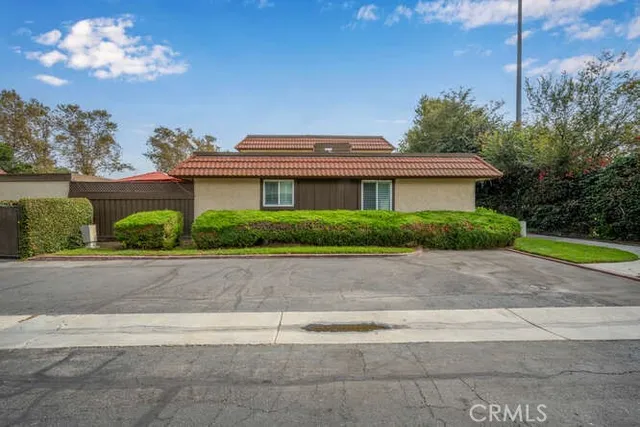 a front view of a house with a yard and potted plants