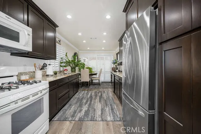 a kitchen with stainless steel appliances kitchen island granite countertop a refrigerator and a sink