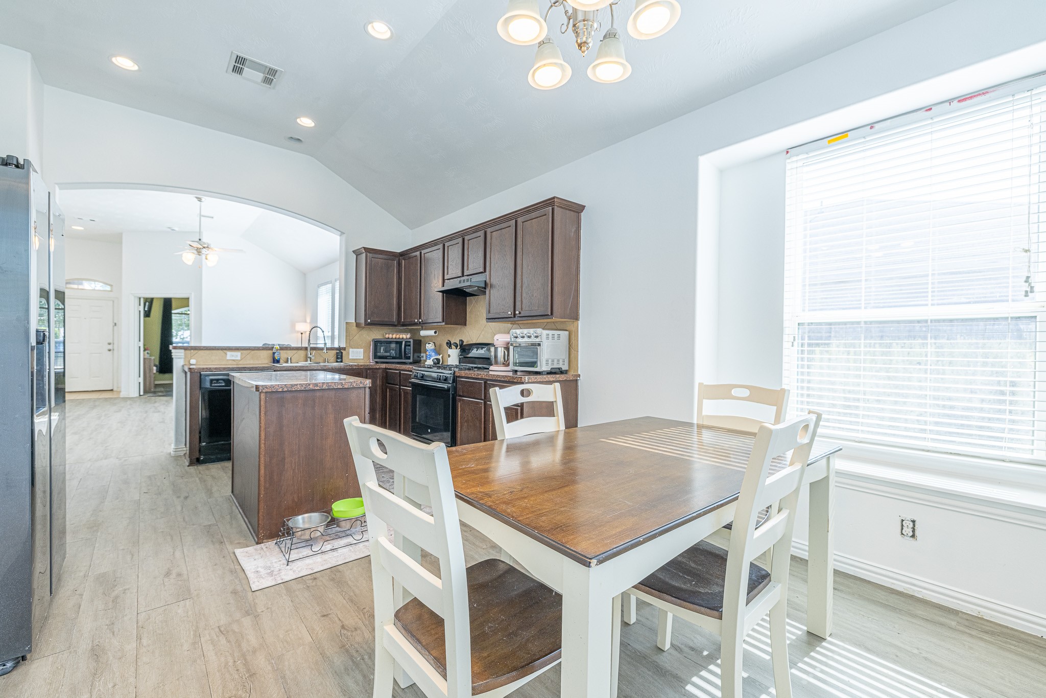 3818 Hunters Trail Baytown, TX 77521 - Photo 13 of 32 a kitchen with a table chairs microwave and cabinets