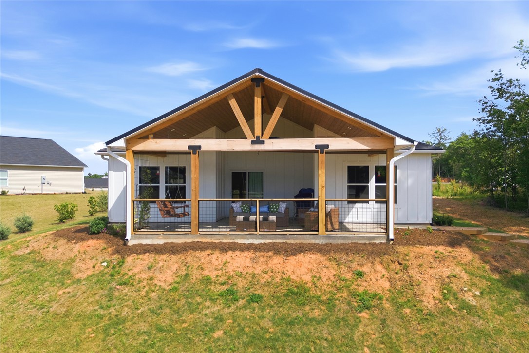 412 Chadwick Lane Walhalla, SC 29691 - Photo 22 of 37 Relax outdoors on this inviting patio with a gable roof, featuring exposed wood beams and a metal railing.
