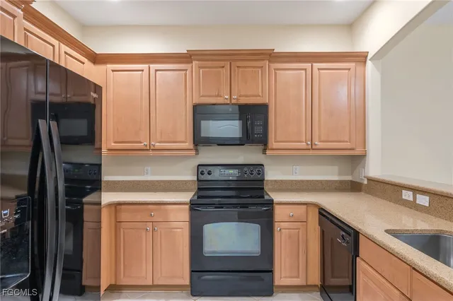 a kitchen with granite countertop white cabinets and stainless steel appliances