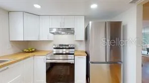 a kitchen with stainless steel appliances granite countertop a refrigerator and a stove
