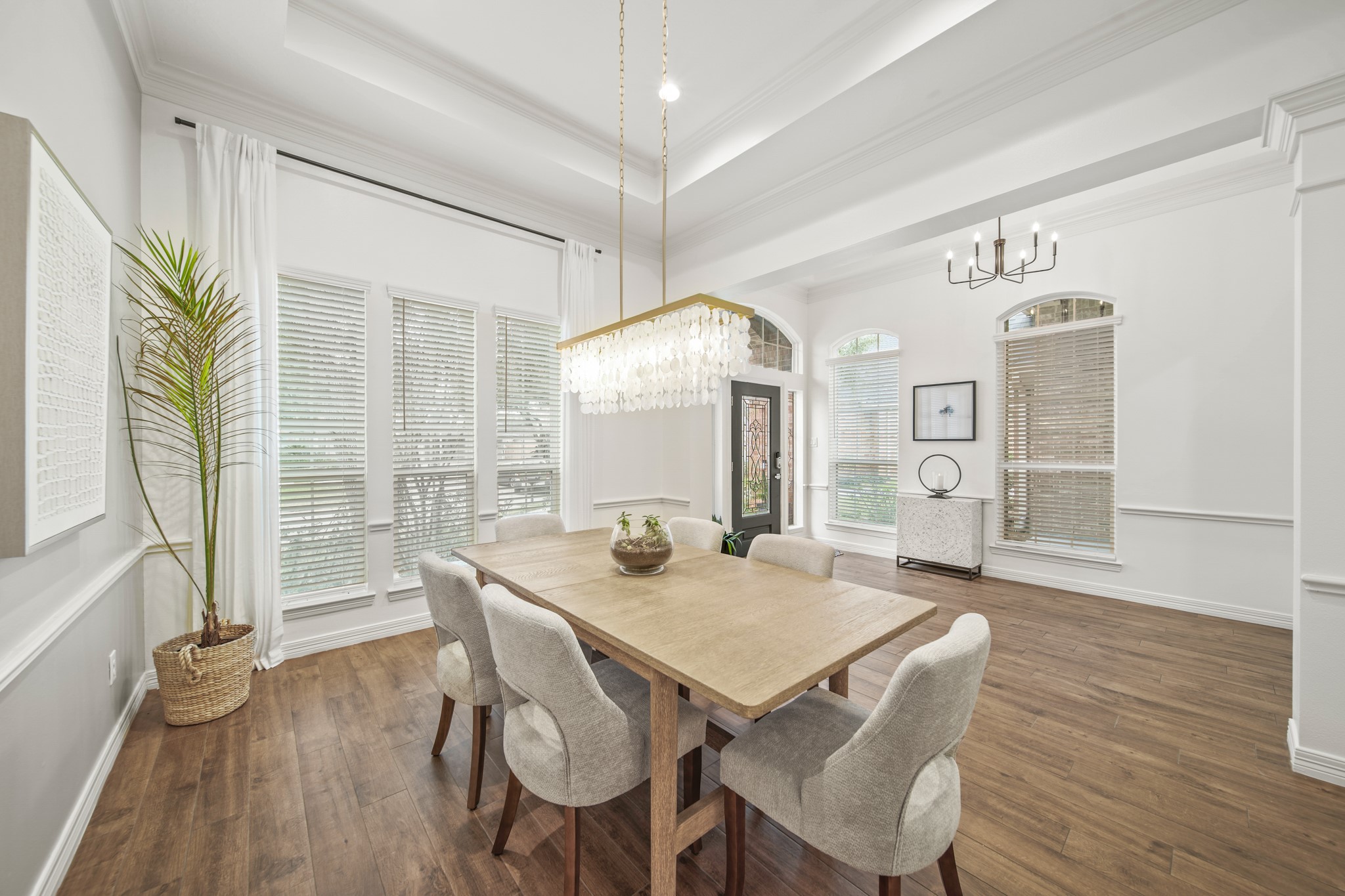 12210 Pebble Meadows Houston, TX 77041 - Photo 3 of 28 Elegant dining room filled with natural light, featuring a tray ceiling, and a statement chandelier