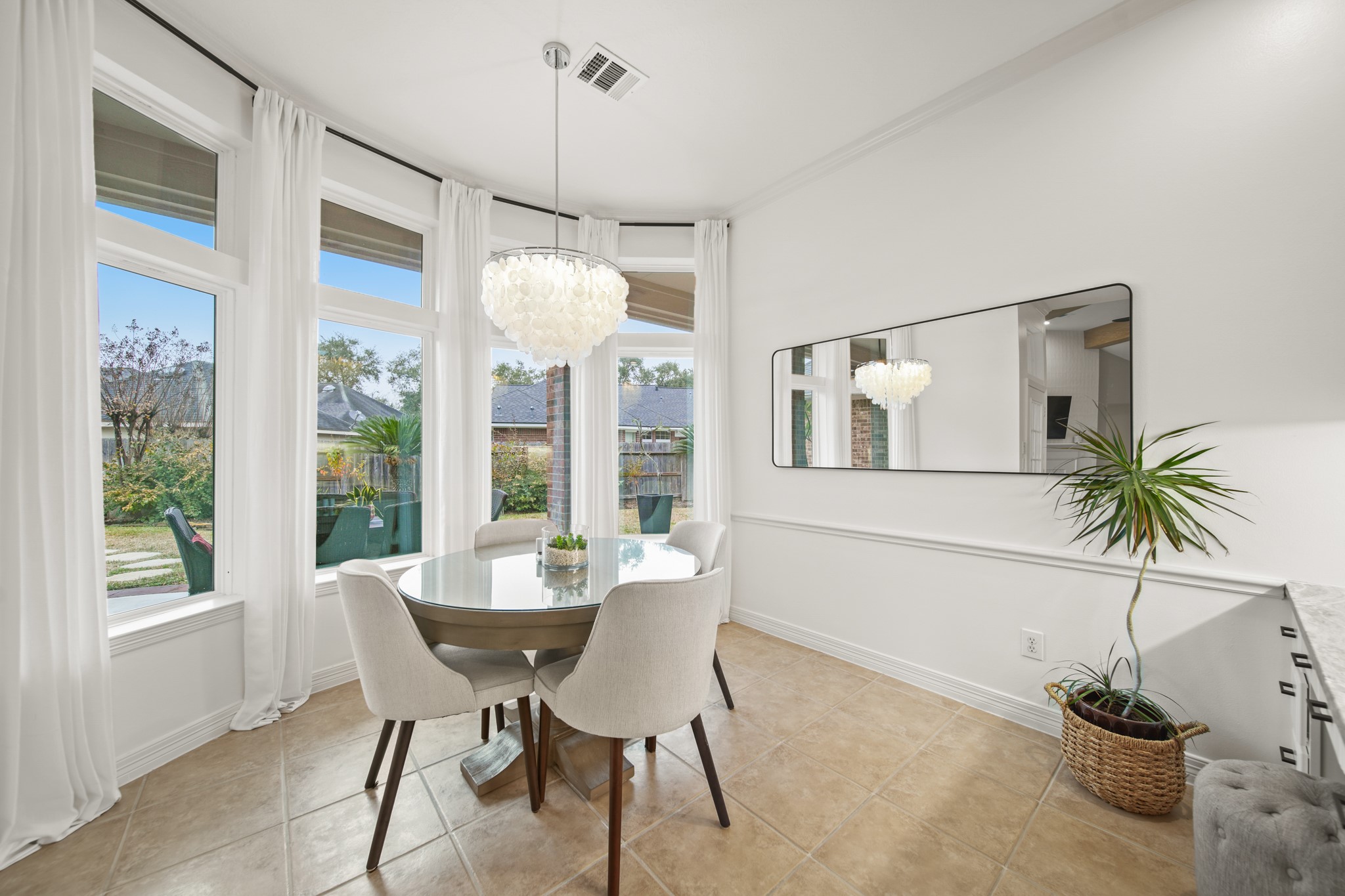 12210 Pebble Meadows Houston, TX 77041 - Photo 10 of 28 A sunlit, airy breakfast nook with a built-in desk and a modern chandelier overlooking the backyard patio