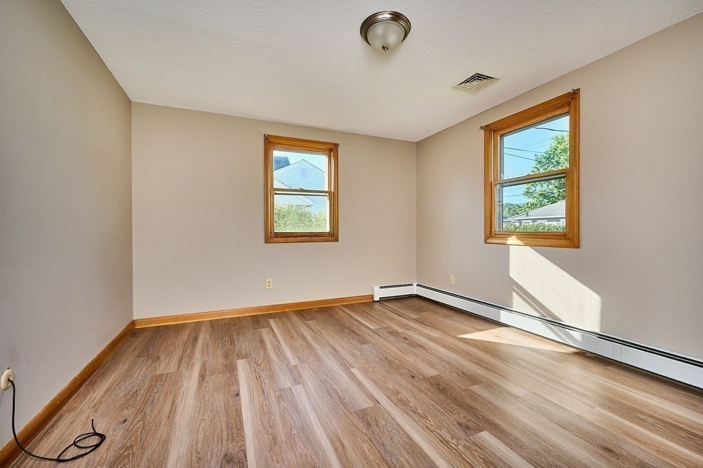 56 Thaddeus Street Chicopee, MA 01020 - Photo 11 of 24 an empty room with wooden floor and windows