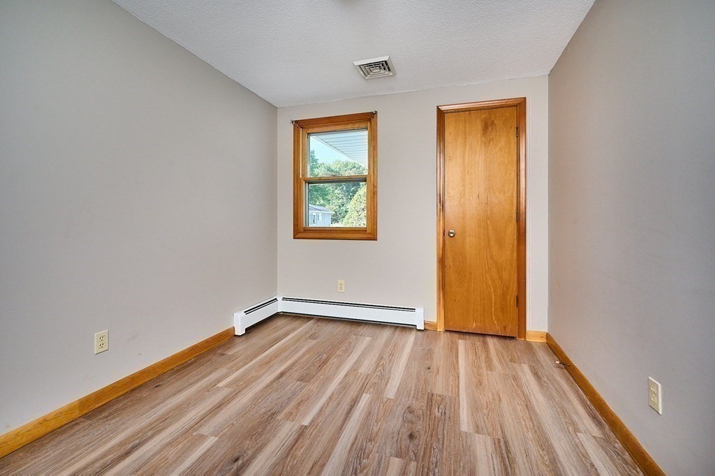 56 Thaddeus Street Chicopee, MA 01020 - Photo 14 of 24 an empty room with wooden floor and windows