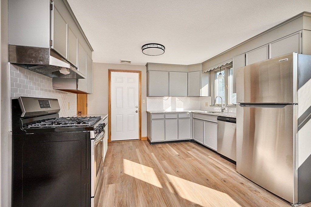 56 Thaddeus Street Chicopee, MA 01020 - Photo 2 of 24 a kitchen with stainless steel appliances granite countertop a refrigerator a stove a sink and a microwave
