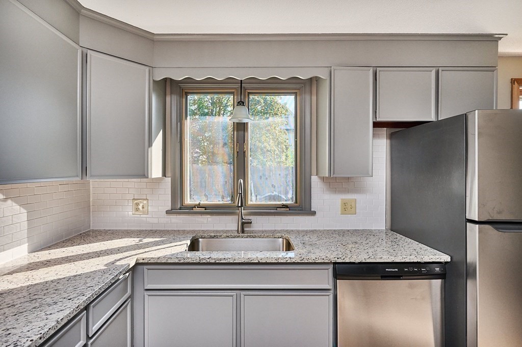 56 Thaddeus Street Chicopee, MA 01020 - Photo 4 of 24 a kitchen with a granite countertop sink and refrigerator