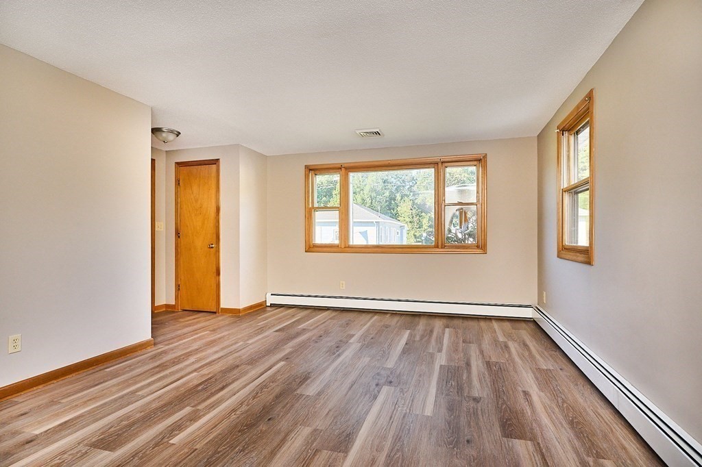 56 Thaddeus Street Chicopee, MA 01020 - Photo 7 of 24 a view of an empty room with wooden floor and a window