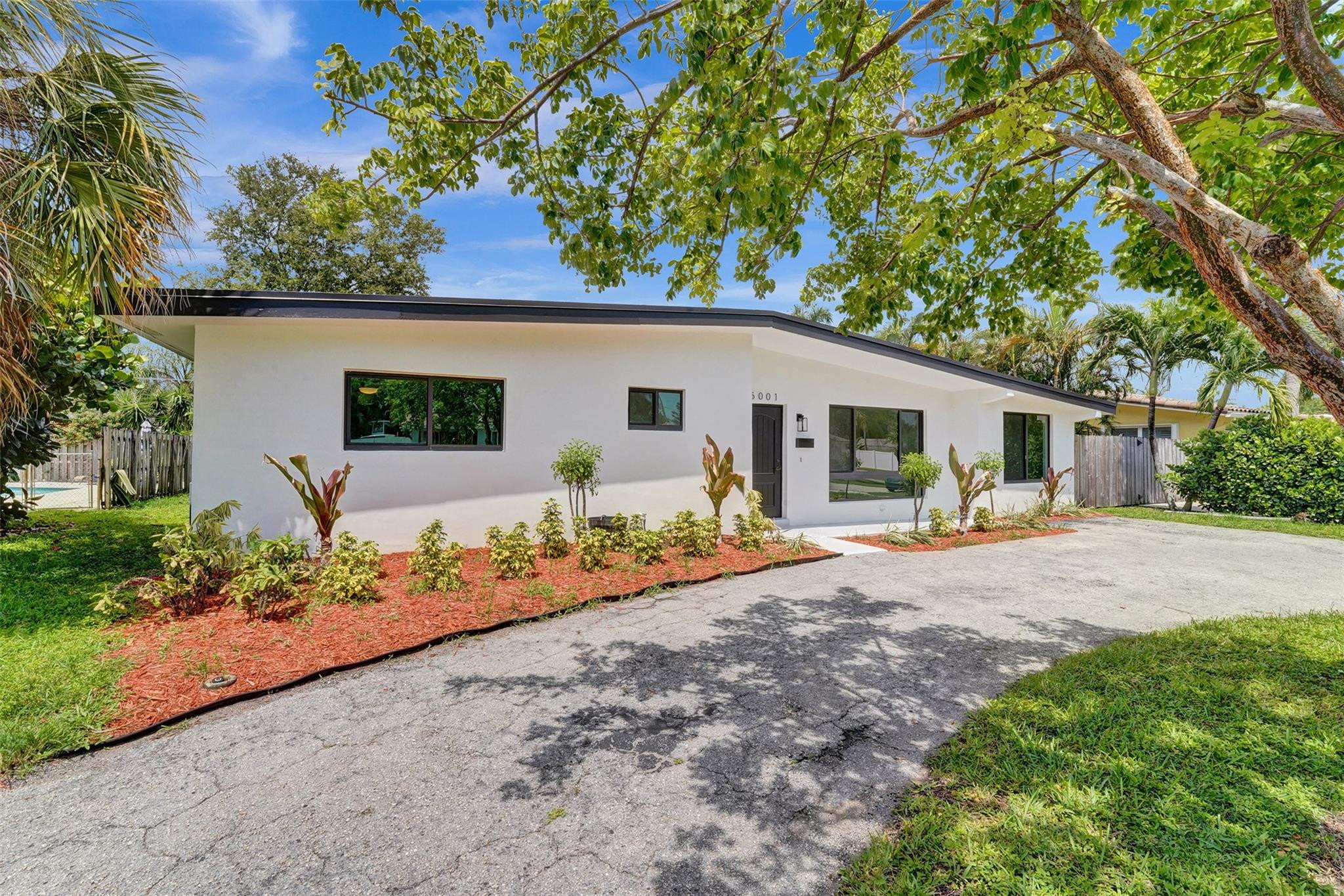 5001 Northeast 23rd Avenue Lighthouse Point, FL 33064 - Photo 1 of 34 a front view of a house with garden