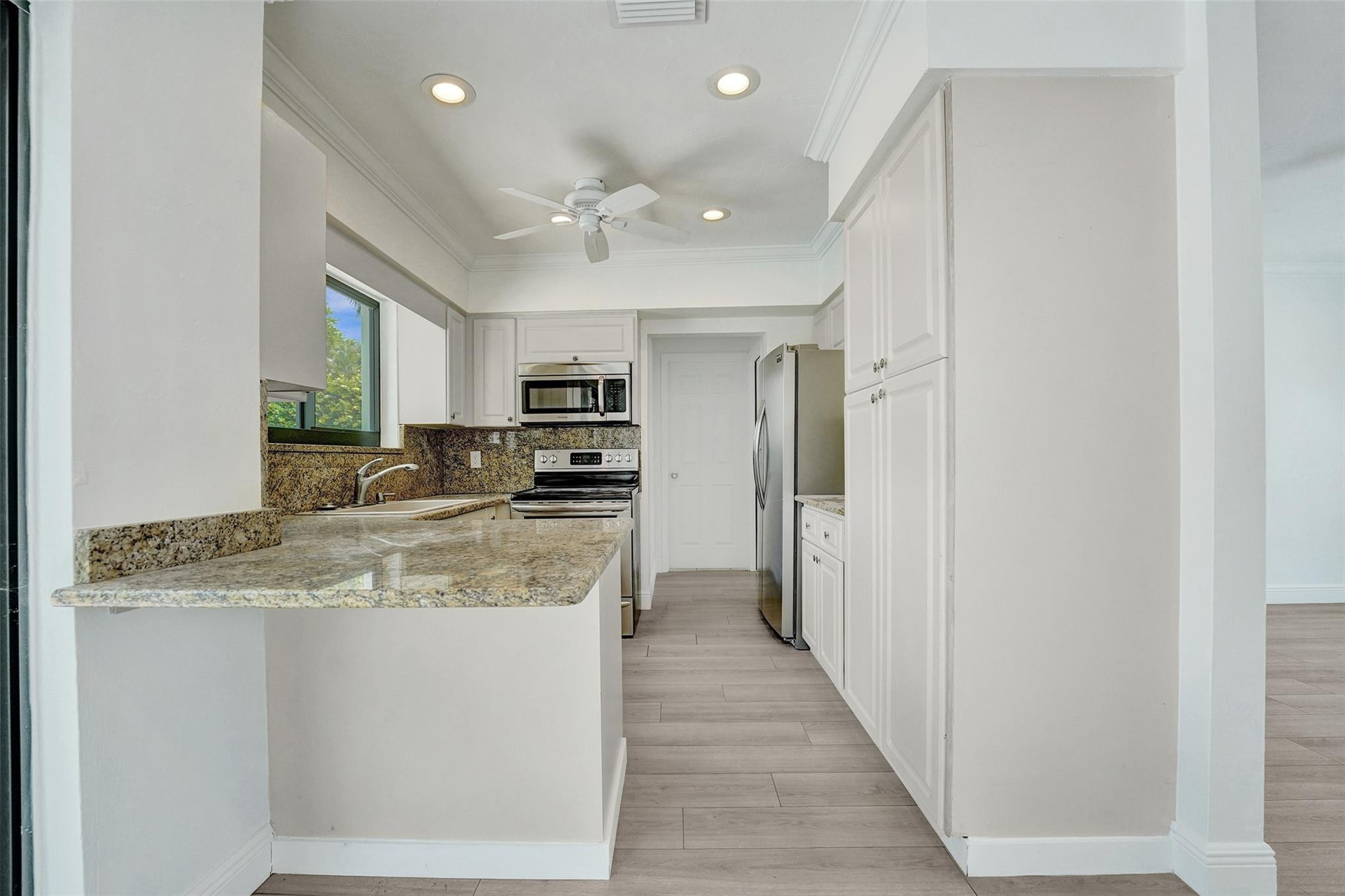 5001 Northeast 23rd Avenue Lighthouse Point, FL 33064 - Photo 12 of 34 a large kitchen with stainless steel appliances granite countertop a refrigerator and a sink