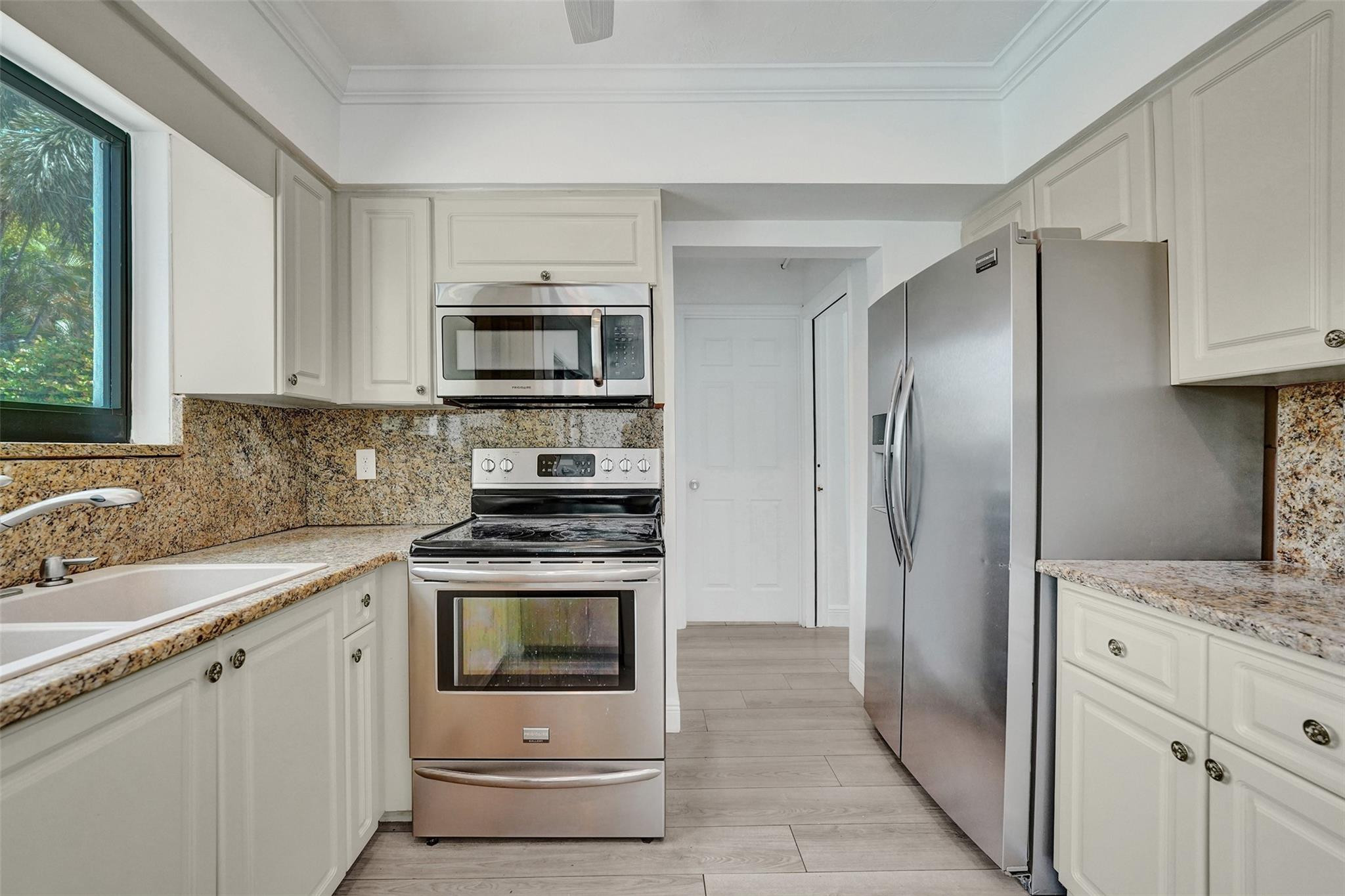 5001 Northeast 23rd Avenue Lighthouse Point, FL 33064 - Photo 14 of 34 a kitchen with stainless steel appliances granite countertop a stove a refrigerator and a sink