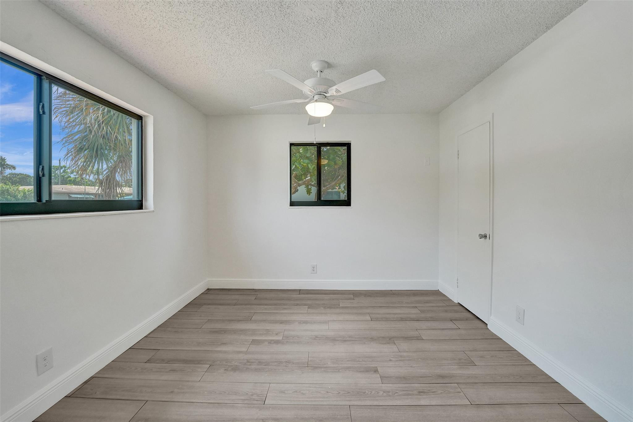 5001 Northeast 23rd Avenue Lighthouse Point, FL 33064 - Photo 20 of 34 a view of an empty room with wooden floor and a window