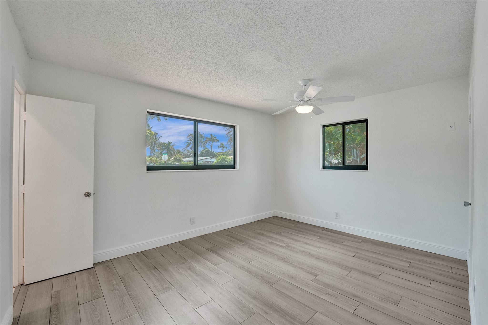 5001 Northeast 23rd Avenue Lighthouse Point, FL 33064 - Photo 21 of 34 a view of empty room with wooden floor and window