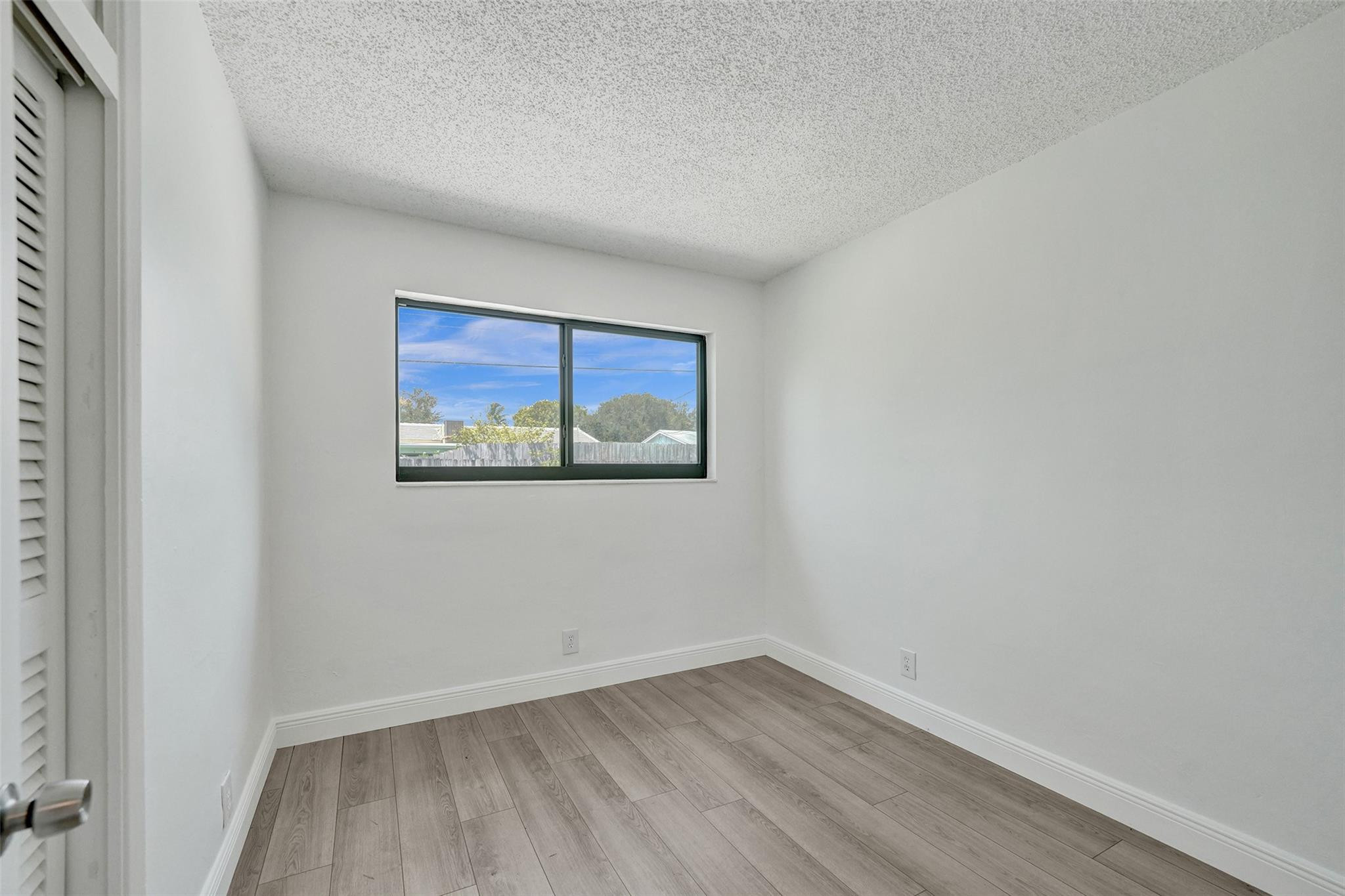 5001 Northeast 23rd Avenue Lighthouse Point, FL 33064 - Photo 24 of 34 a view of an empty room with wooden floor