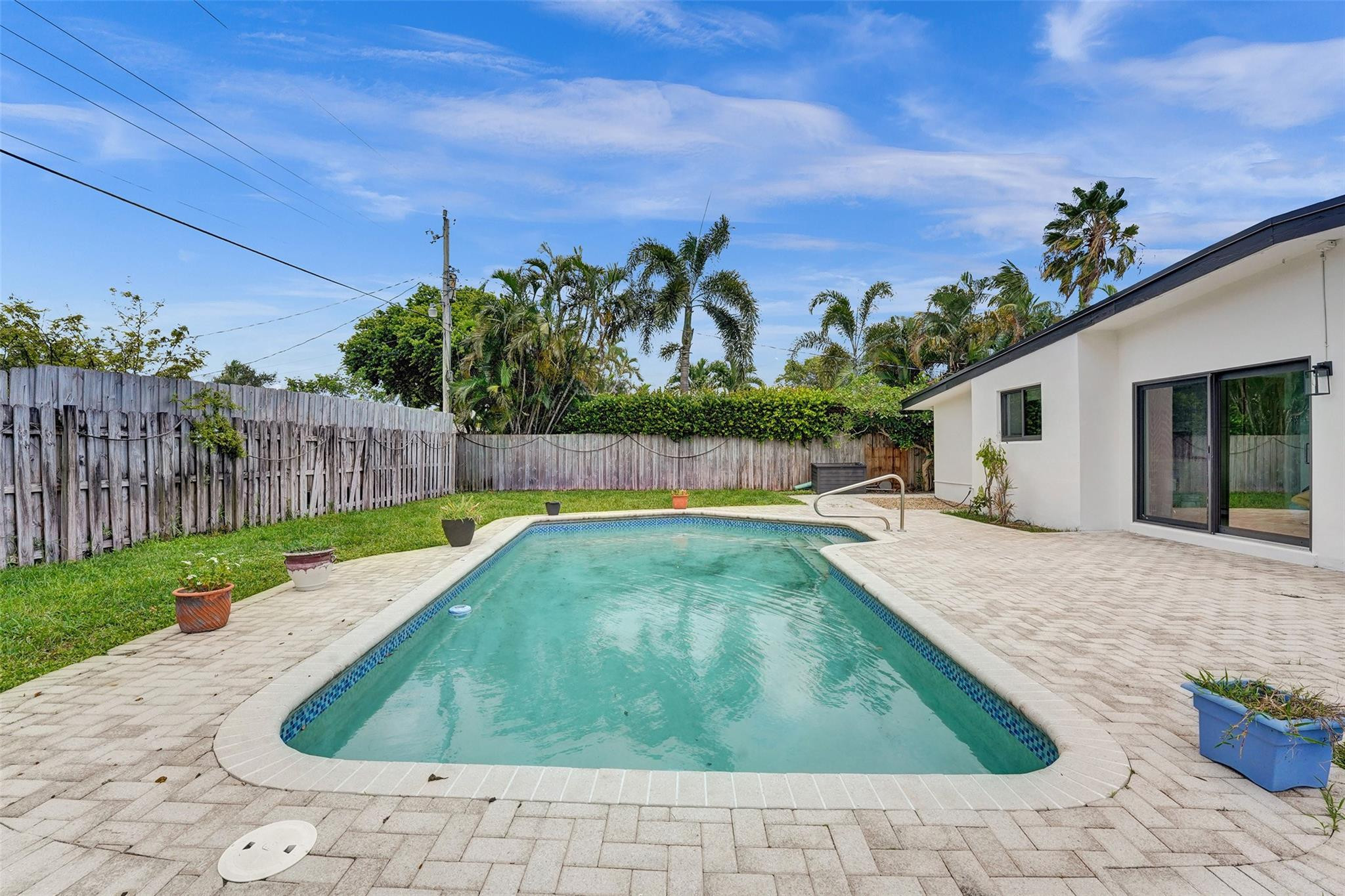 5001 Northeast 23rd Avenue Lighthouse Point, FL 33064 - Photo 27 of 34 a view of a backyard with a barbeque and wooden fence