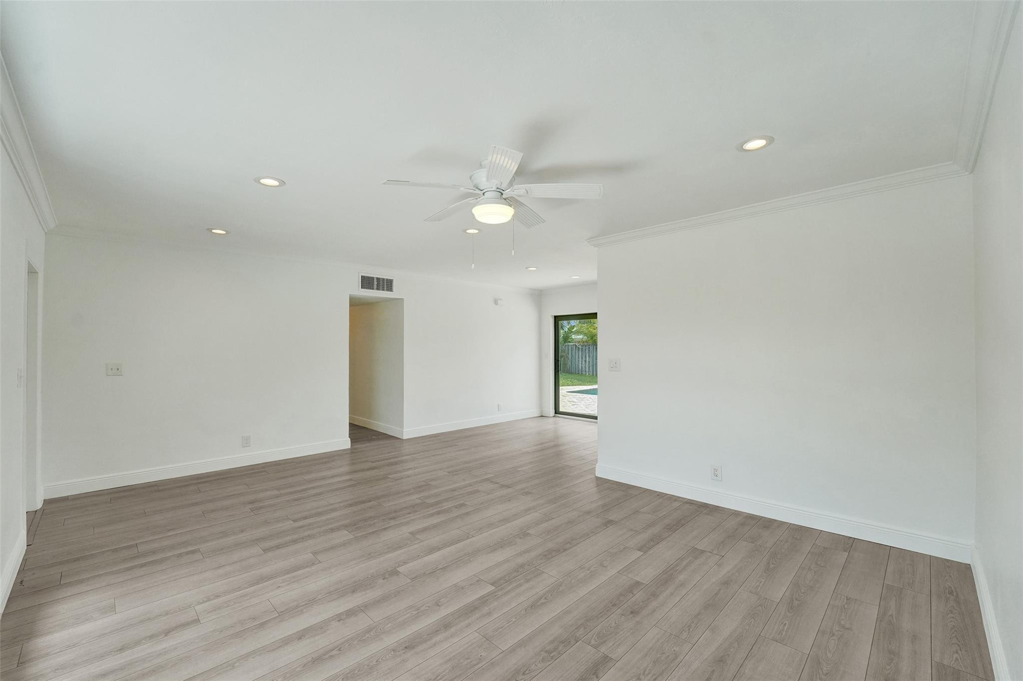 5001 Northeast 23rd Avenue Lighthouse Point, FL 33064 - Photo 7 of 34 an empty room with wooden floor and a ceiling fan