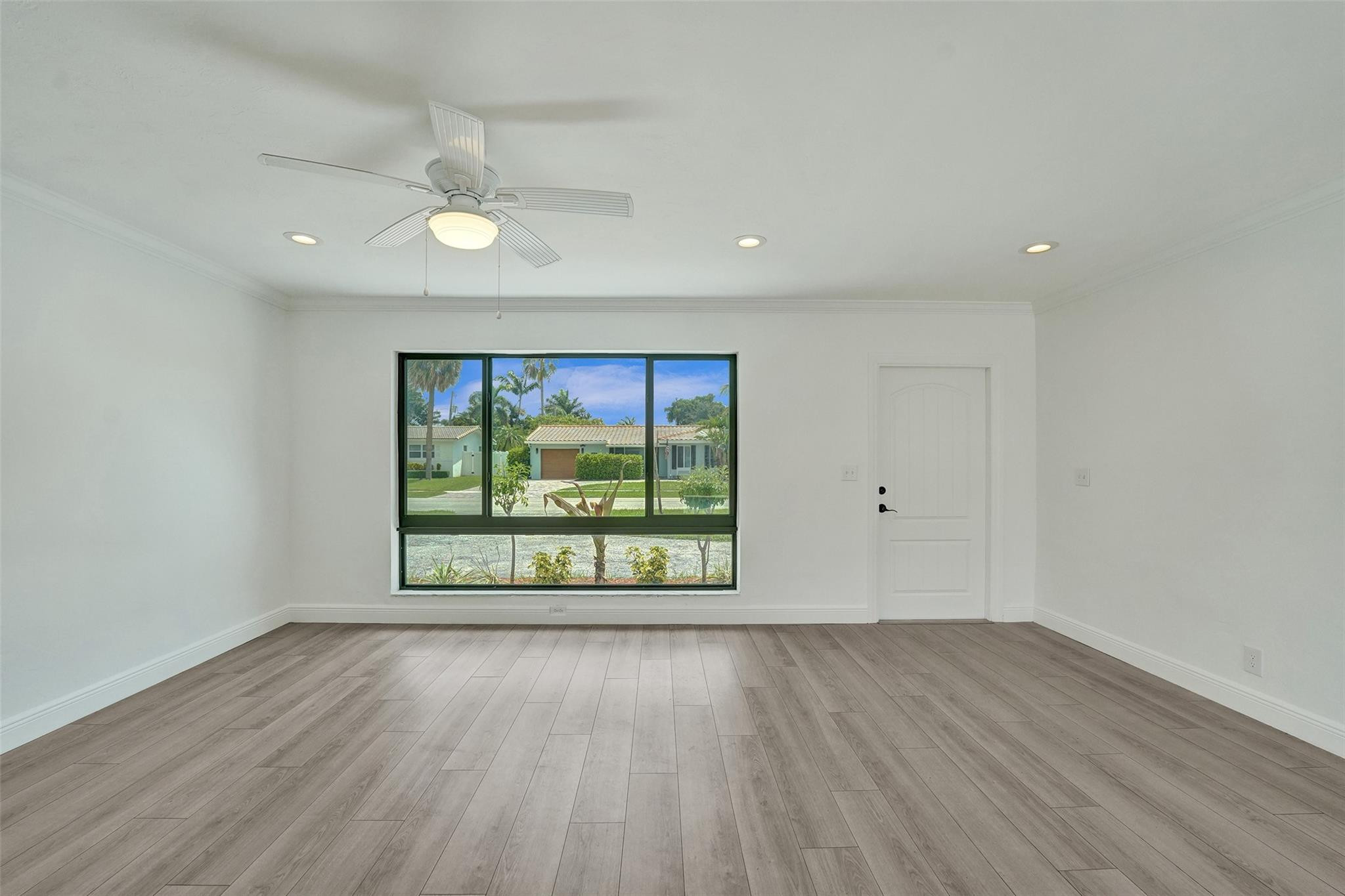 5001 Northeast 23rd Avenue Lighthouse Point, FL 33064 - Photo 8 of 34 an empty room with wooden floor and windows