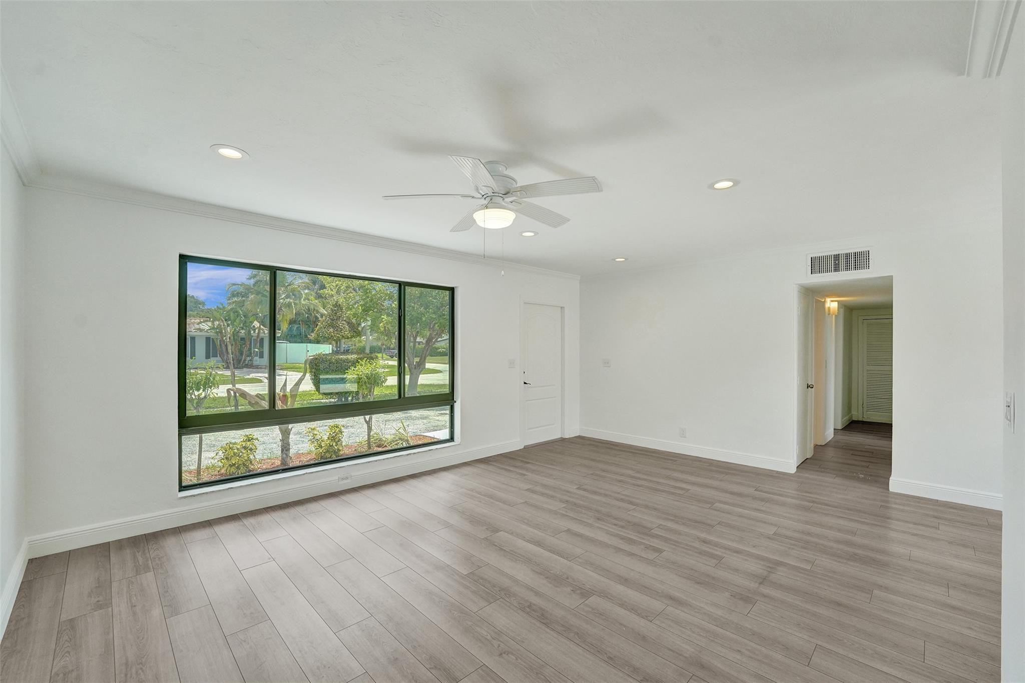 5001 Northeast 23rd Avenue Lighthouse Point, FL 33064 - Photo 9 of 34 an empty room with wooden floor and windows