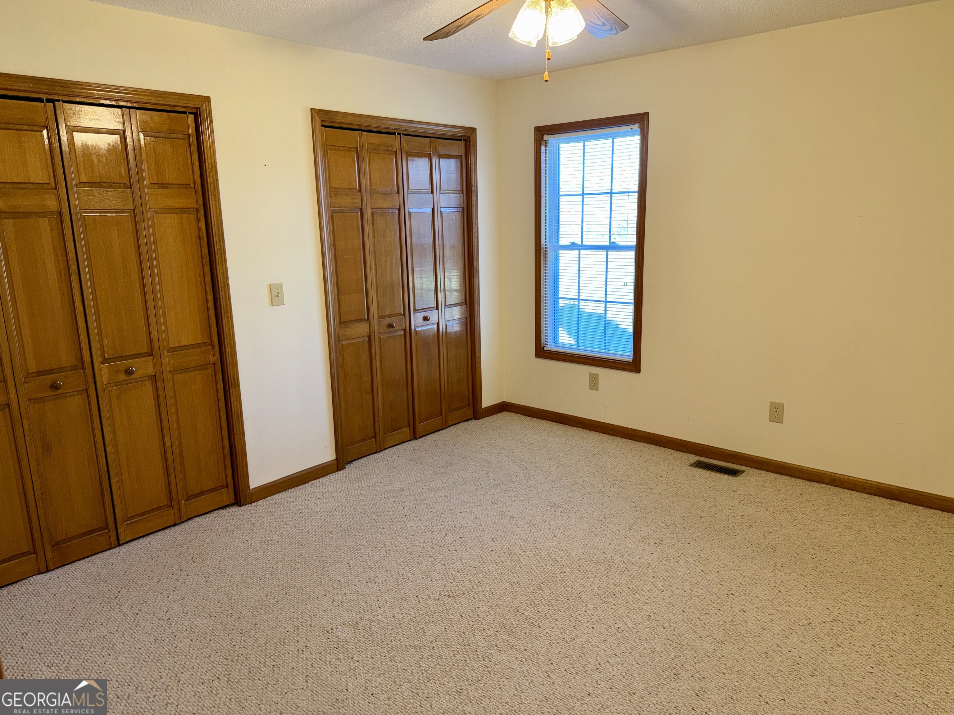 494 Broad Street Bowman, GA 30624 - Photo 39 of 65 an empty room with windows and chandelier fan