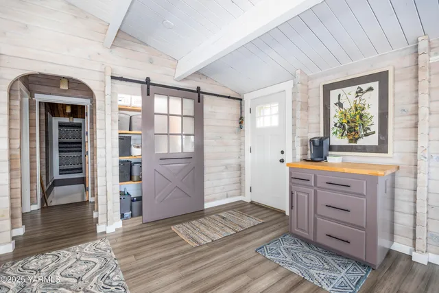 a kitchen with granite countertop a stove a sink dishwasher a refrigerator and cabinets with wooden floor