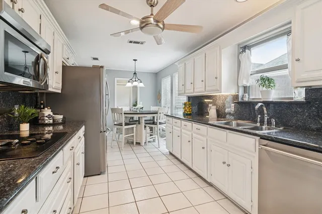 a kitchen with cabinets appliances a sink and a counter top space