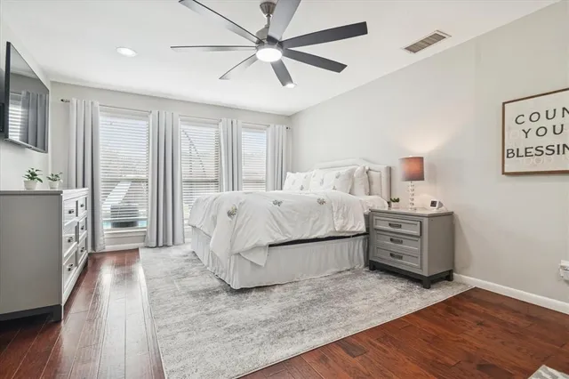a bedroom with a bed dresser and a flat tv screen