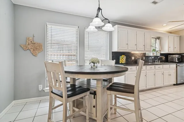 a kitchen with stainless steel appliances kitchen island granite countertop a sink a stove a table and chairs