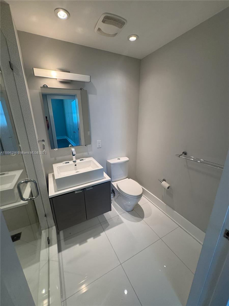5970 Indian Creek Drive, Unit PH3 Miami Beach, FL 33140 - Photo 19 of 37 a bathroom with a sink mirror vanity and toilet