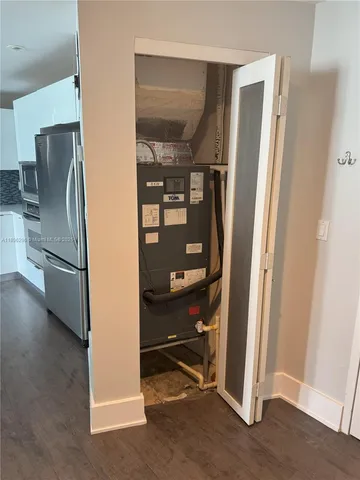 a view of a kitchen with a refrigerator and an empty room