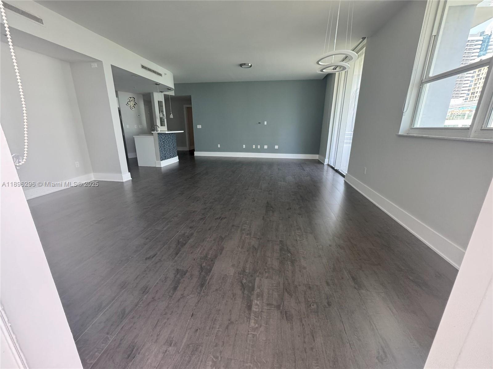 5970 Indian Creek Drive, Unit PH3 Miami Beach, FL 33140 - Photo 3 of 37 an empty room with wooden floor and windows