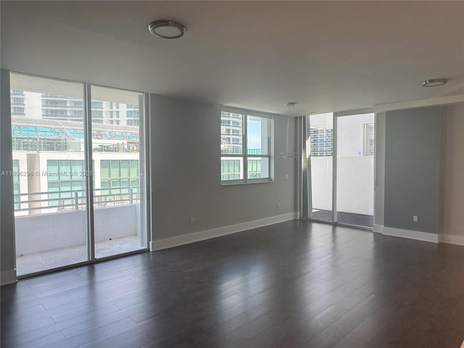 5970 Indian Creek Drive, Unit PH3 Miami Beach, FL 33140 - Photo 7 of 37 a view of an empty room with wooden floor and a window
