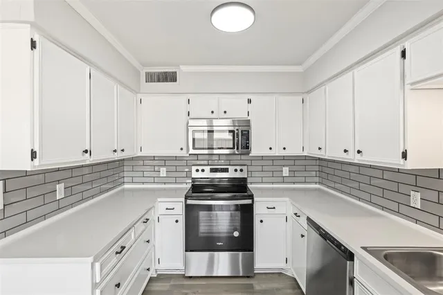 a kitchen with cabinets appliances and a sink