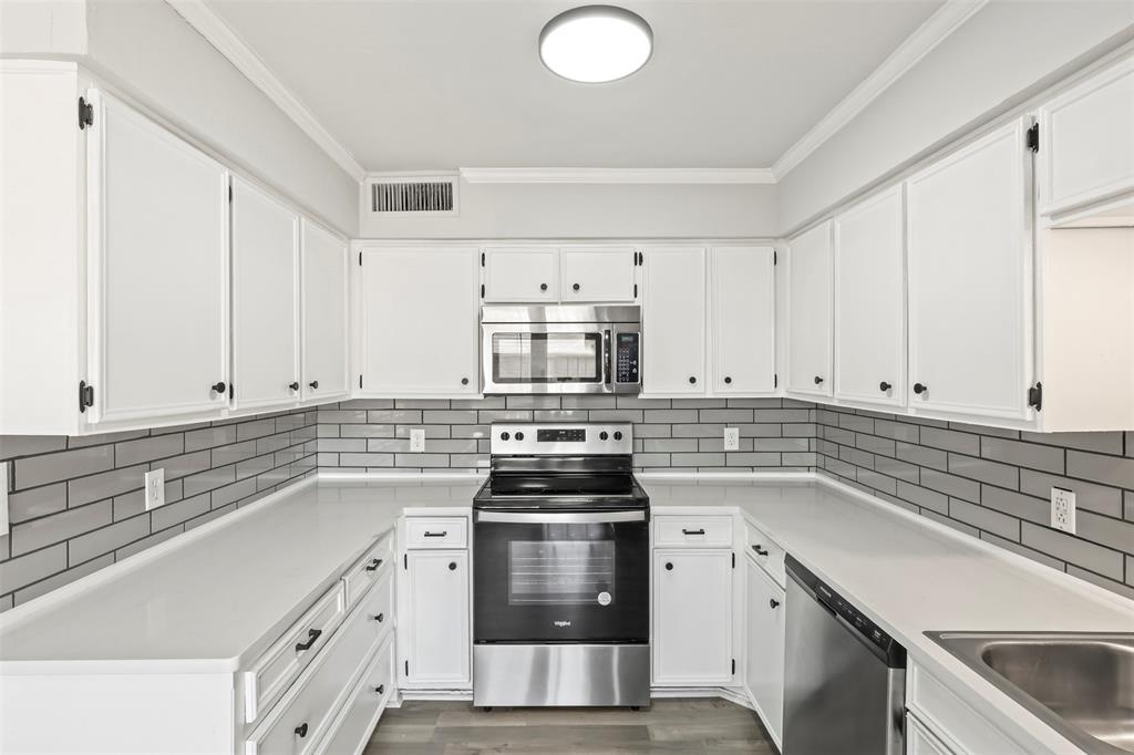 a kitchen with cabinets appliances and a sink