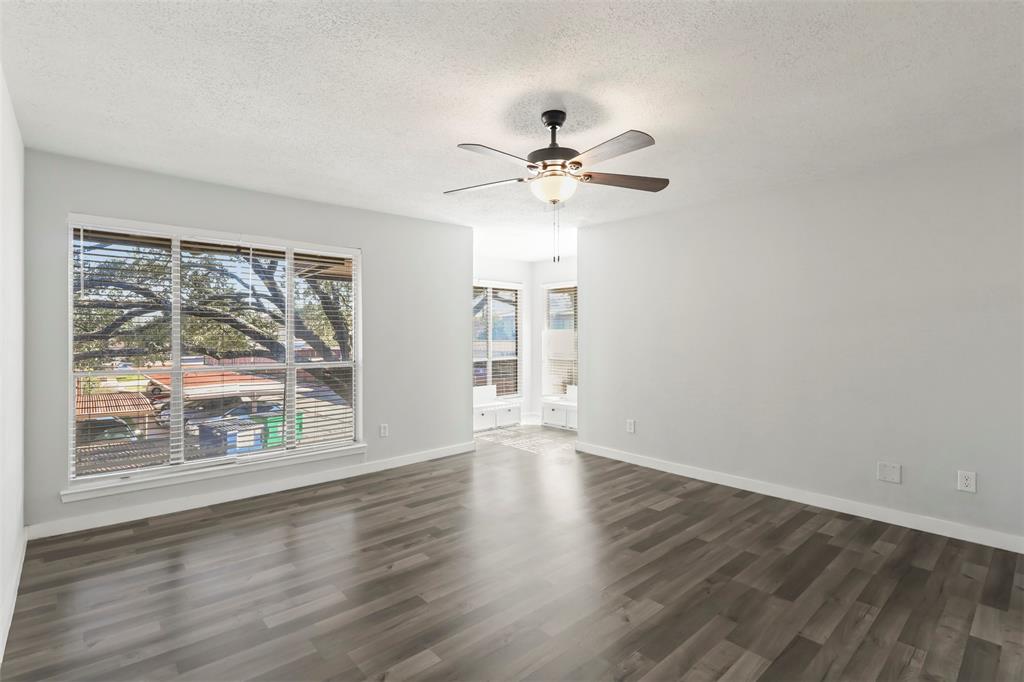 10526 Stone Canyon Road, Unit 201 Dallas, TX 75230 - Photo 11 of 28 a view of an empty room with a window and wooden floor