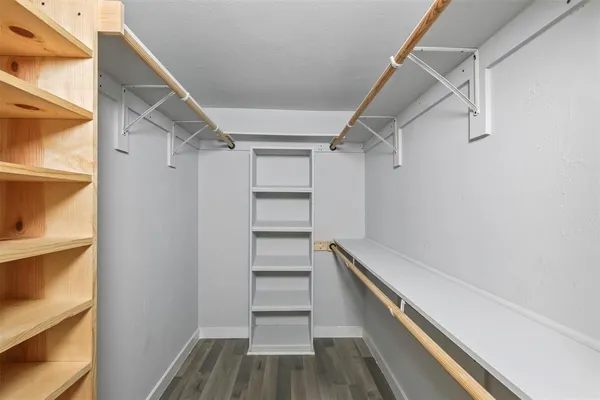 a view of walk in closet with empty racks