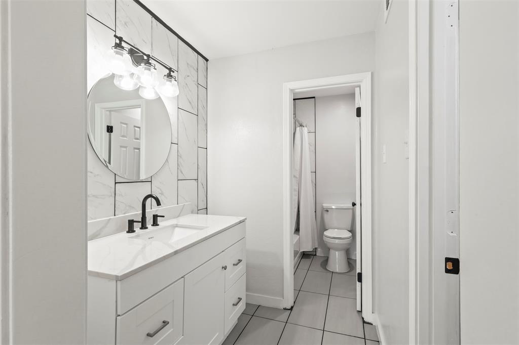 10526 Stone Canyon Road, Unit 201 Dallas, TX 75230 - Photo 13 of 28 a bathroom with a double vanity sink mirror and toilet